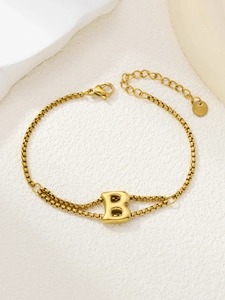 Detail van de goudkleurige roestvrijstalen dubbele armband met hoofdletter B hanger