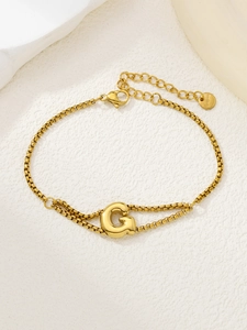 Gedetailleerde macro van de vergulde roestvrijstalen schakelarmband met een letter G-hanger