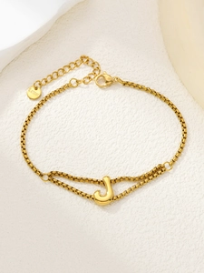Detail van verstelbare gouden roestvrijstalen armband met een stijlvolle letter J hanger