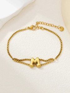 Detail van een gouden 316L roestvrijstalen dubbellaagse armband met letter M hanger