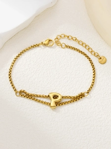 Detail van een dubbellaagse gouden roestvrijstalen armband met een 3D-letter P-hanger