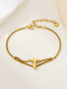 Detail van de dubbellaagse gouden roestvrijstalen armband met gepolijste letter T-hanger