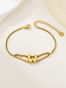 Detail van een vergulde roestvrijstalen letter W-hanger aan een dubbellaagse armband