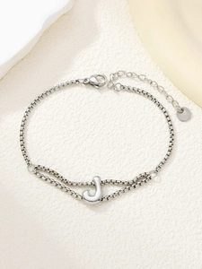 Detail van zilveren box chain armband met karabijnsluiting en letter J hangertje