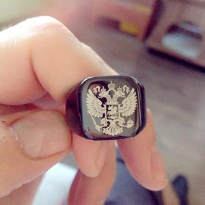 Macro shot of a black signet ring featuring a silver Russian double-headed eagle emblem