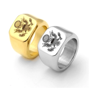 Macro detail of gold and silver signet rings with engraved eagle crest and polished finish