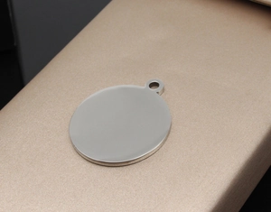 Close-up of polished round stainless steel pet tag with ring for custom engraving