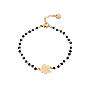 Detailed macro view of black faceted beads and gold four-leaf clover pendant bracelet