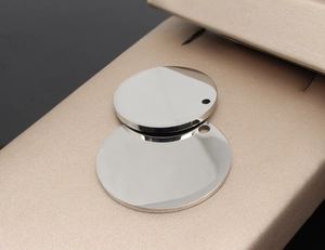 Macro detail of mirror-polished stainless steel round dog tags on champagne satin