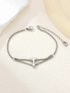 Detail van een dubbellaagse roestvrijstalen armband met een gepolijste letter T-hanger