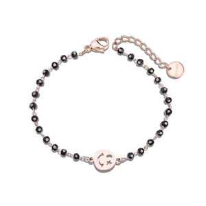 Detail of rose gold stainless steel bracelet with black faceted beads and moon pendant