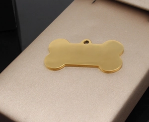 Polished gold bone-shaped stainless steel pet ID tag on elegant champagne satin background