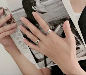 Minimalist silver-colored wide band rings with a polished flat surface on a lifestyle background