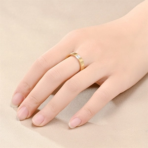 Detail of matte brushed gold titanium ring with rectangular zircon stone worn on finger