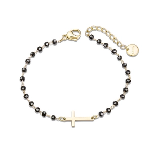 Macro view of gold stainless steel beaded bracelet featuring a center cross pendant