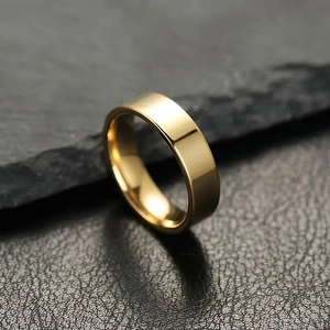 Polished gold titanium steel minimalist band ring on dark slate background