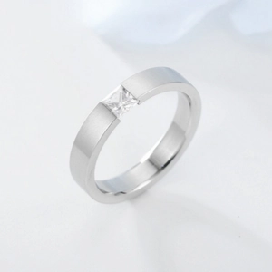 Detail of brushed silver titanium ring with princess-cut square cubic zirconia stone
