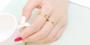 Close-up of stacked gold titanium rings featuring a textured sandblasted surface detail