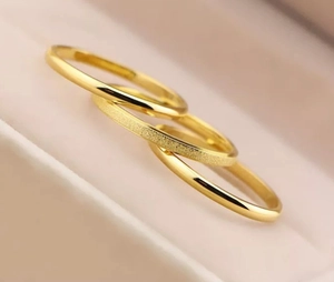 Macro shot of interlocking triple steel rings with matte and polished golden finishes