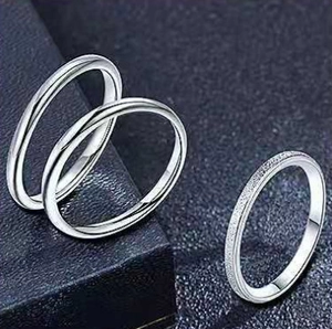 Detail of three-piece silver titanium steel ring set with polished and frosted finishes