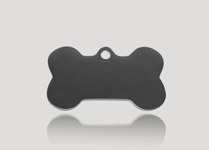 Macro shot of a matte black bone-shaped stainless steel pet ID tag with a top hanging hole