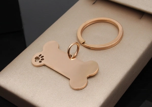 Close-up of bone-shaped rose gold pet ID tag with hollow paw print on gift box