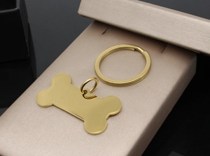 Detail of bone-shaped stainless steel pet ID tag in gold finish on luxury gift box