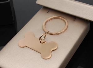 Detailed macro view of bone-shaped stainless steel pet tag in polished rose gold finish