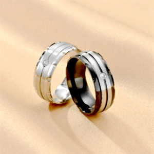 Detail of couple rings with brushed titanium steel finish and small center diamond inlay