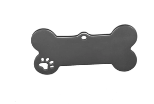 Detail of bone-shaped stainless steel pet ID tag with a matte finish and cutout paw print