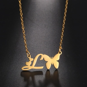 Detailed view of golden butterfly and letter L pendant necklace on black background