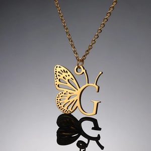 Gouden ketting met vlinder letter G hanger op een reflecterend oppervlak voor vrouwen