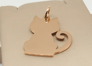 Close-up of a rose gold cat-shaped pet ID tag with a polished mirror finish surface