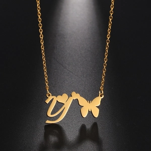 Macro detail of golden butterfly and letter Y pendant on a delicate link chain