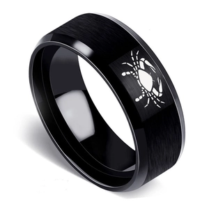 Detail of black brushed stainless steel Cancer zodiac ring with polished beveled edges