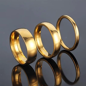 Drie gouden gepolijste titanium stalen ringen in breed, medium en dun met spiegelglans