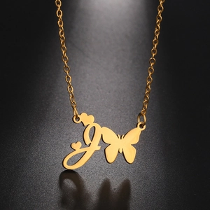 Macro detail of golden letter J pendant necklace with butterfly and heart charms