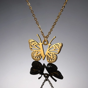 Detailopname van gouden vlinderhanger ketting met centraal letter V ontwerp