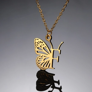 Detailopname van vergulde roestvrijstalen ketting met vlinder en letter F hanger