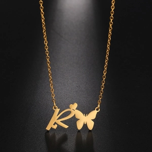 Detail of a gold butterfly, heart and letter R pendant on a stainless steel chain