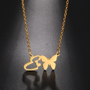 Detailed view of a gold butterfly and heart pendant on a chain with reflection