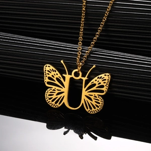 Macro-opname van gouden vlinderhanger met letter U detail aan een fijne ketting