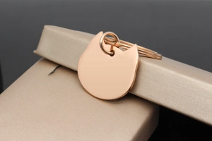 Polished rose gold cat-shaped pet ID tag on a display stand with a glossy mirror finish
