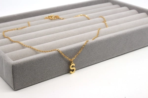 Detailansicht der goldenen Edelstahlkette mit S-Buchstaben-Anhänger auf Samtpad