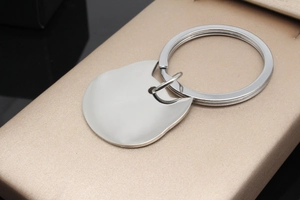 Detailed close-up of a cat-shaped polished stainless steel pet ID tag with mirror finish