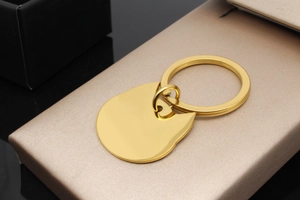 Macro detail of gold-plated cat-shaped pet ID tag with mirror-polished finish