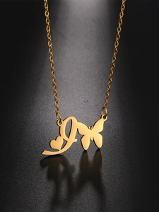 Detailed macro shot of gold butterfly and letter L heart pendant on a stainless steel chain