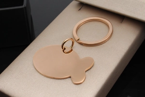 Polished rose gold fish-shaped pet ID tag on a premium jewelry display box