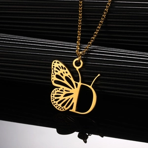 Detailopname van de gouden roestvrijstalen ketting met vlinder en letter D hanger sieraad