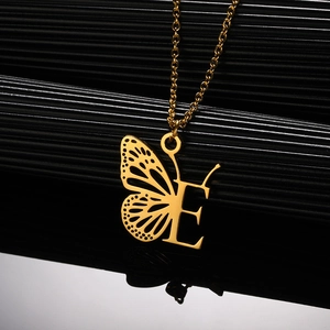 Detail van gouden roestvrijstalen vlinderletter E-hanger aan een fijne O-schakelketting